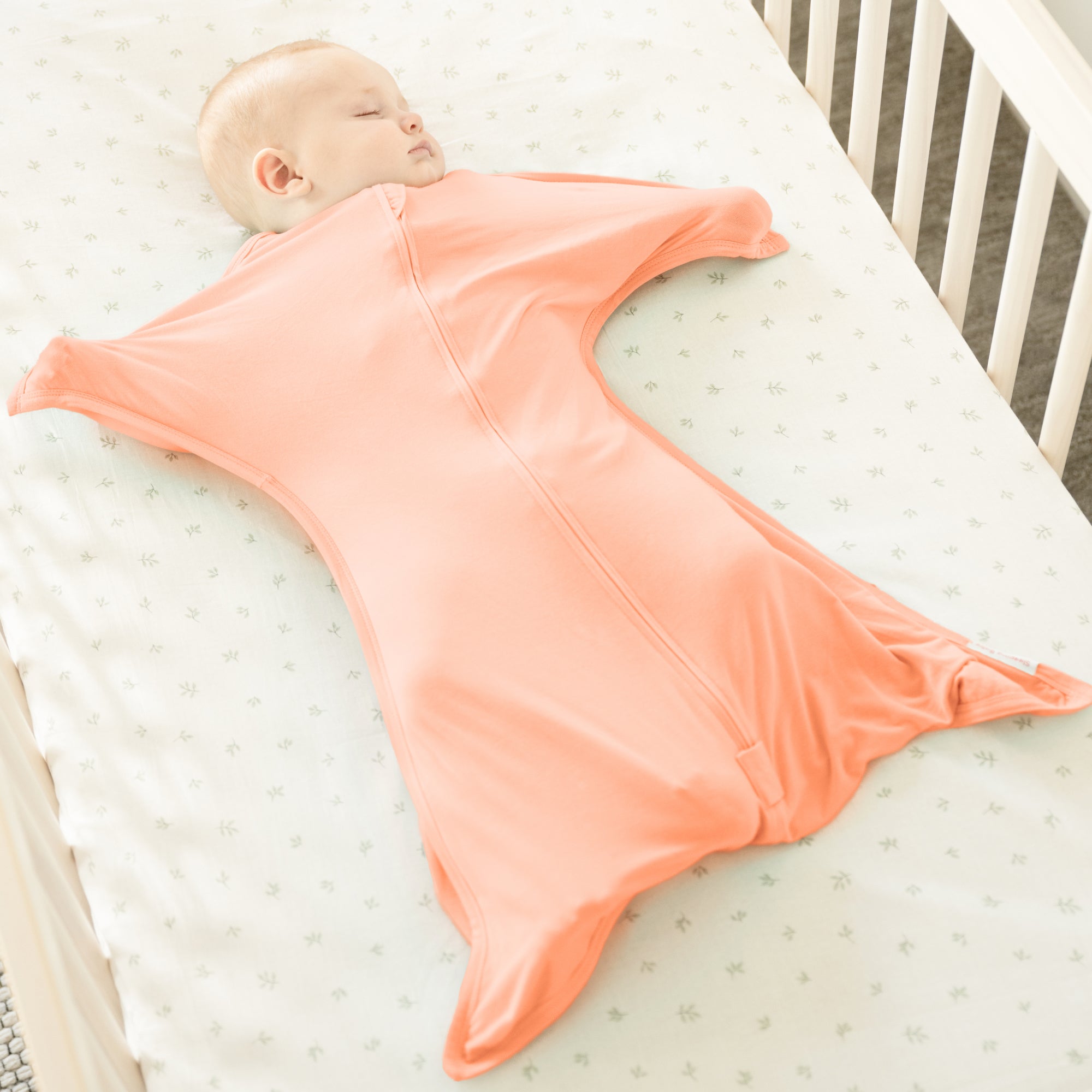 Baby wearing Peach Fuzz bamboo Zipadee-Zip swaddle