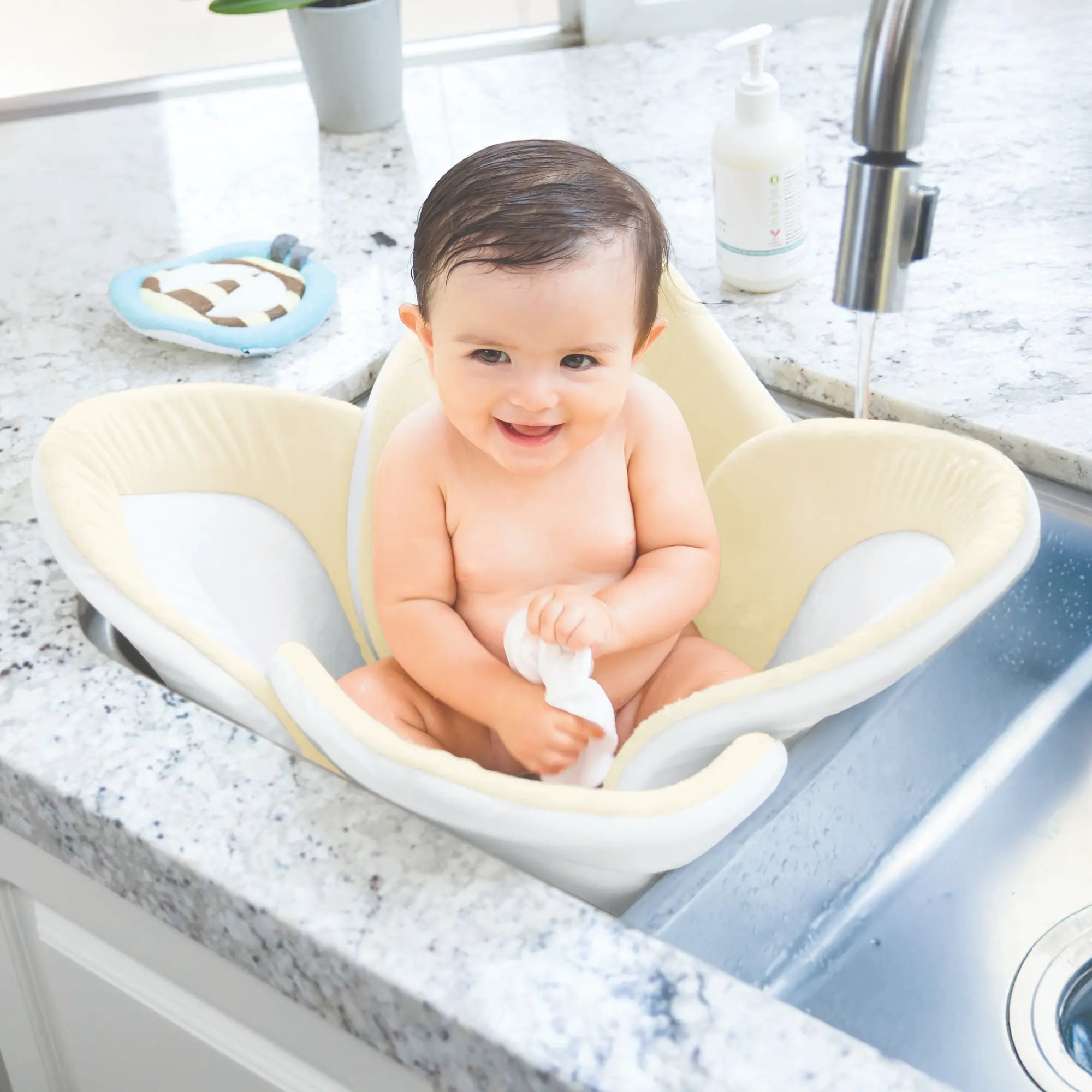 Baby sitting in a Blooming Baby ColorBloom bath seat