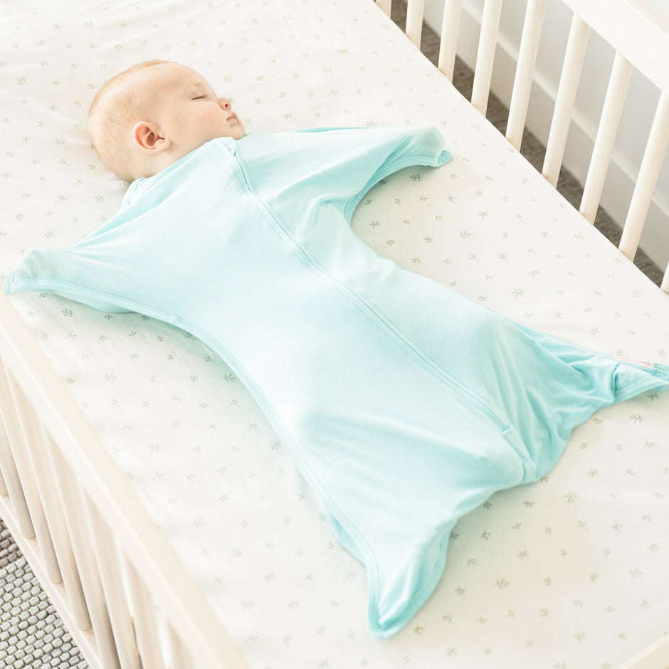 Baby sleeping in Sea Glass bamboo swaddle transition