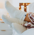 Load image into Gallery viewer, Close-up of feet in cozy Little Giraffe socks with a blurred background
