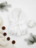 Load image into Gallery viewer, White robe surrounded by pine cones and branches on a light background
